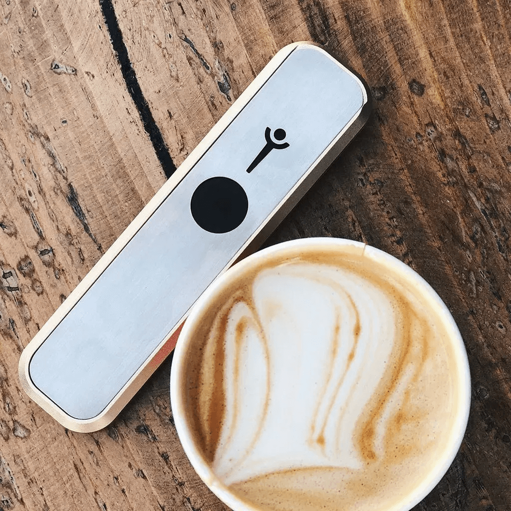 Genius Pipe β High Expectations edition on table beside espresso-style coffee β lifestyle image.