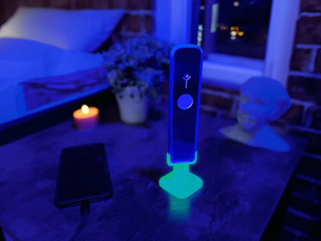 Genius “Lit” Stand glowing while holding Genius Pipe on corner table – lifestyle photo.