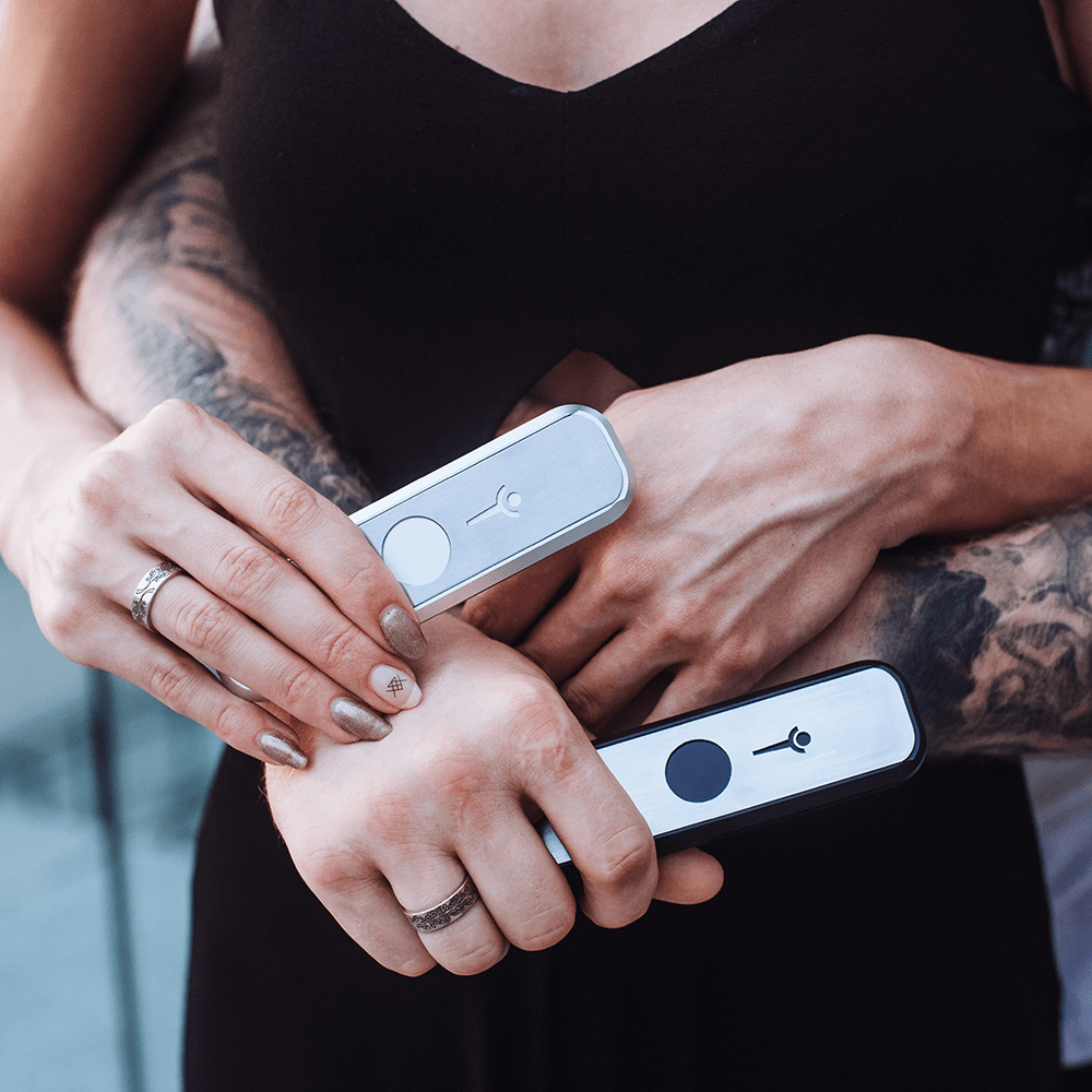 Two people holding Genius Pipe Mini Silver and Black – lifestyle photo showing hands holding Genius Pipes.